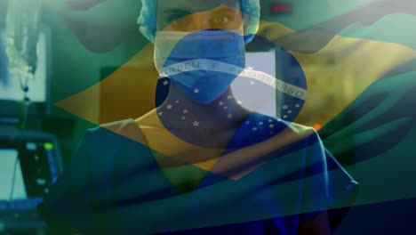 animation of brazilian flag waving over caucasian female doctor wearing surgery mask and cap