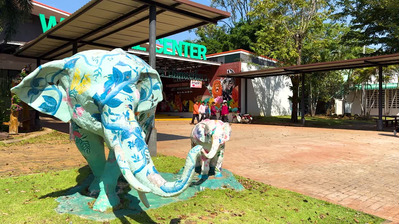 estatuas de elefantes pintadas en la entrada de un parque