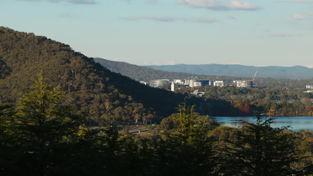 Broad view of Canberra CBD with Black Mountain and a highway running through the frame, captured from the arboretum's scenic heights.