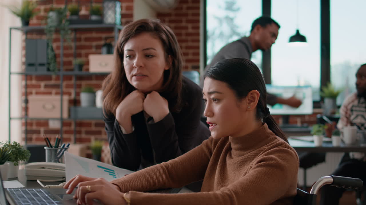 Female colleagues analyzing business charts on documents