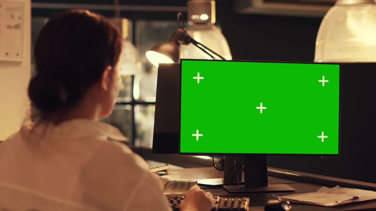 Woman working with greenscreen template on computer