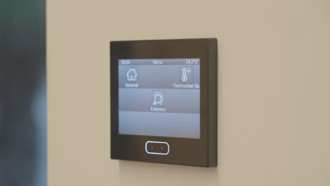 digital smart home automation control panel mounted on a wall for temperature control