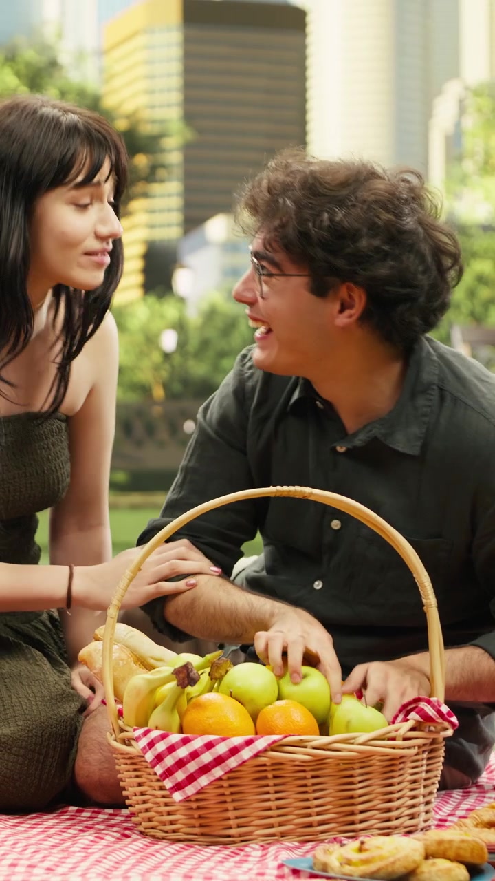Video verticale: Coppia innamorata che scherza con la frutta dal cestino da picnic