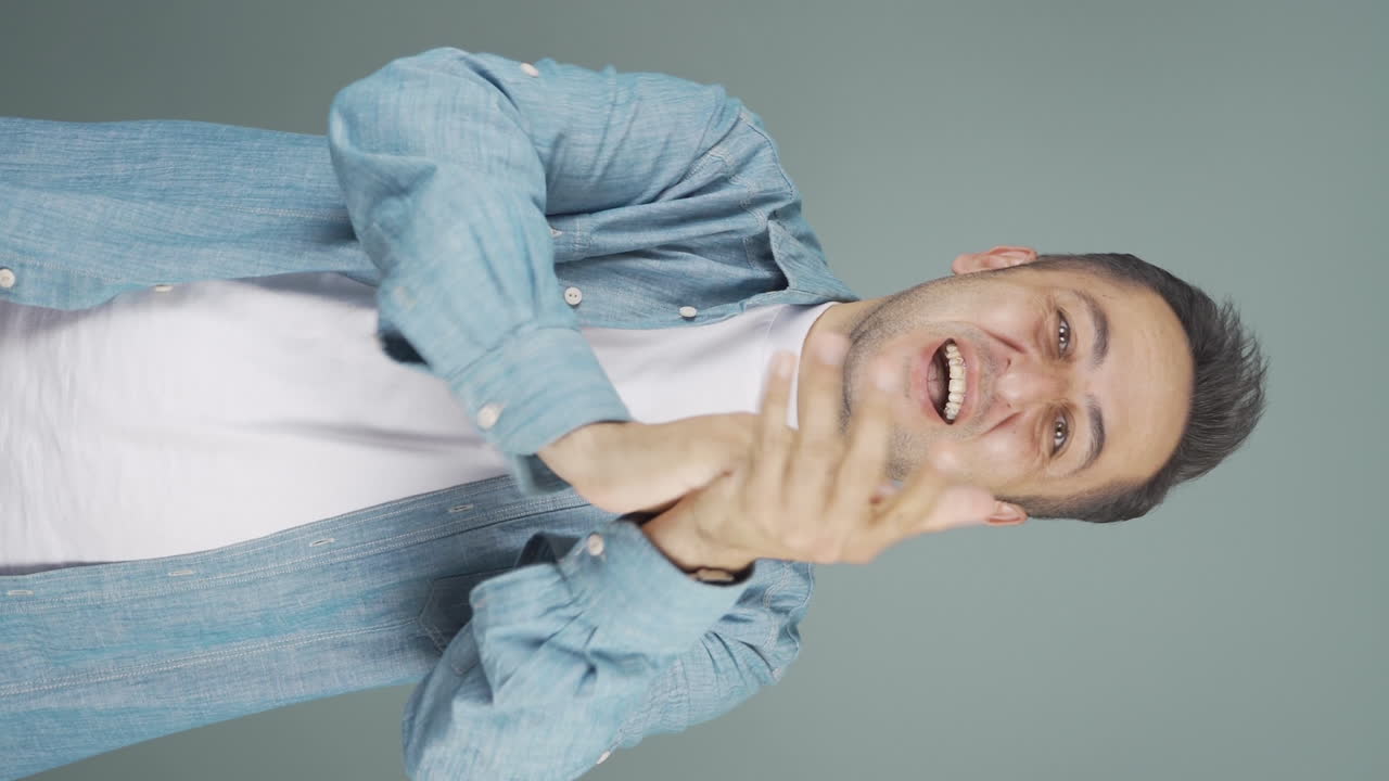 카메라에 흥분하여 박수를 치는 남자의 수직 비디오.