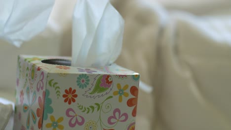 male hand reaching for a tissue while in bed