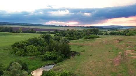 beautiful green meadows separated by a winding river. small groves of diverse trees are located on the shore. fields and forests in the background. a soothing natural landscape.
