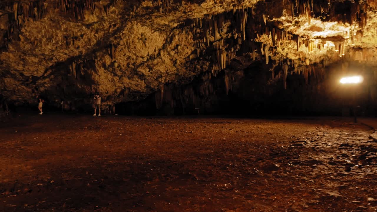 Drogarati Cave on Cephalonia Island illuminated in orange, Greece - panning shot
