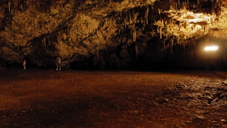 Drogarati-Cave-on-Cephalonia-Island-illuminated-in-orange,-Greece---panning-shot