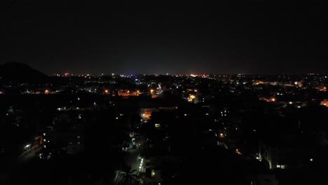 Drone-video-moving-in-night-skyline-with-city-house-lights-and-vehicles-plying-on-highway