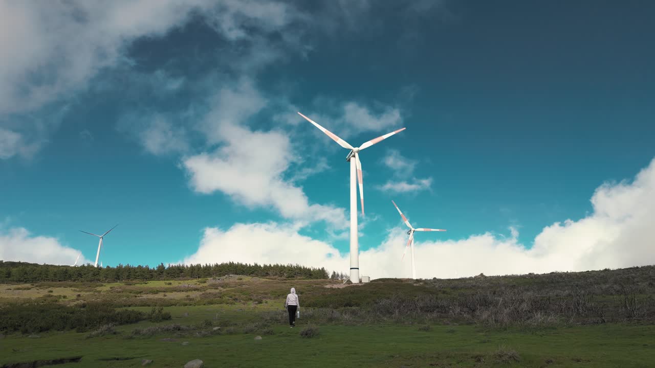 Woman walking near the wind turbines in Fanal, Madeira island, Portugal