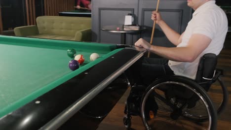 hombres adultos con discapacidad en silla de ruedas juegan al billar en el club