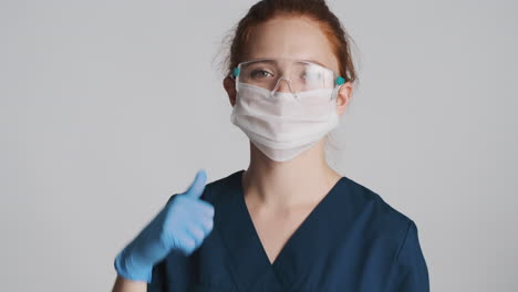 Redheaded-doctor-in-front-of-camera-on-gray-background.