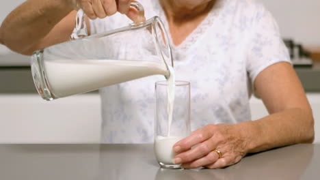 woman pouring glass of milk