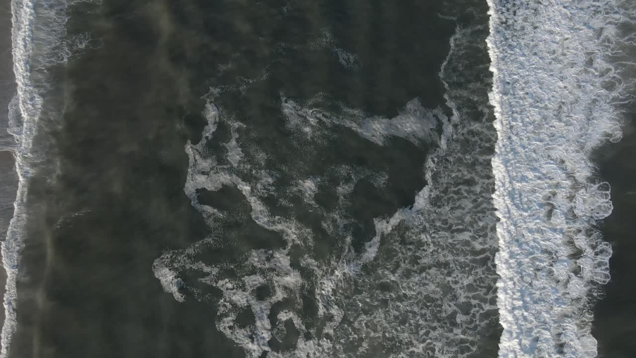 Sea Waves With Foam Moving Through The Sandy Beach - Aerial Top Down, Pan Up