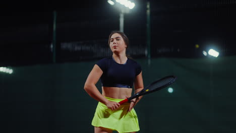 woman playing tennis at night