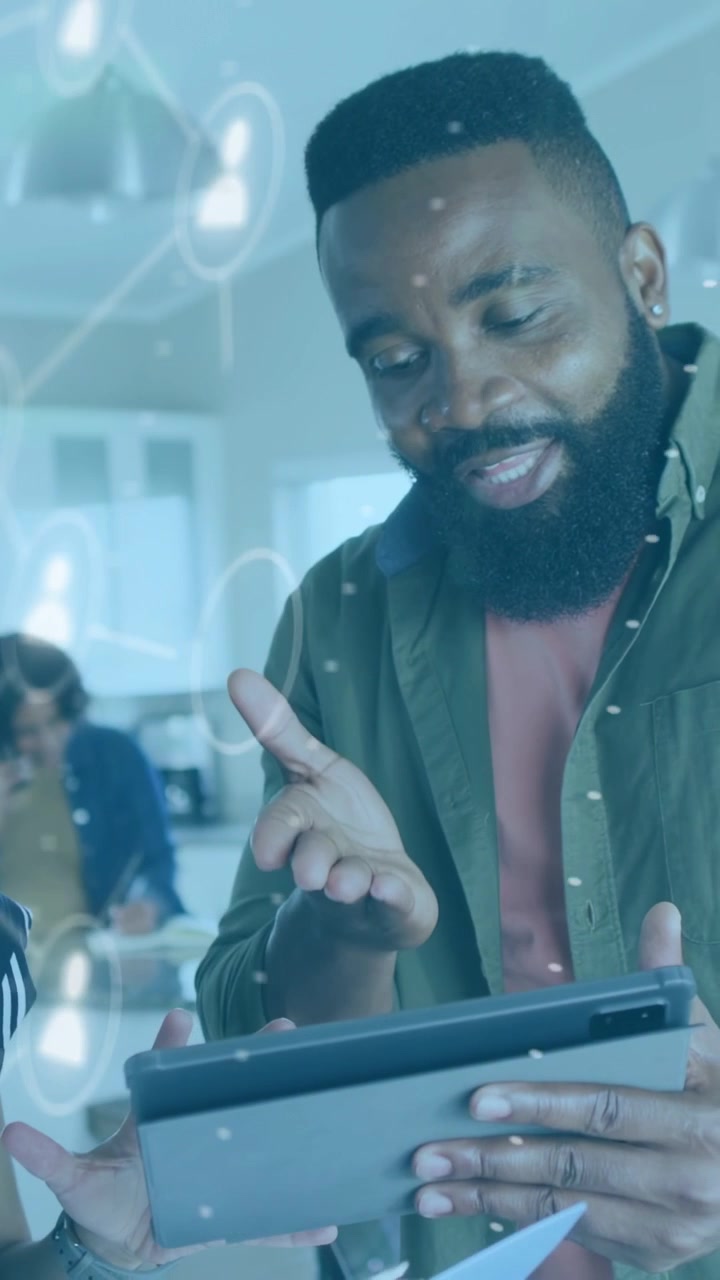 Vertical video: Man tapping tablet and explaining tech plan while user icons hovering near screen