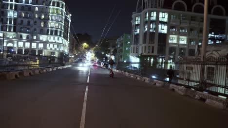 Rider-making-stunt-riding-in-the-city-standing-on-seat-in-the-night-city