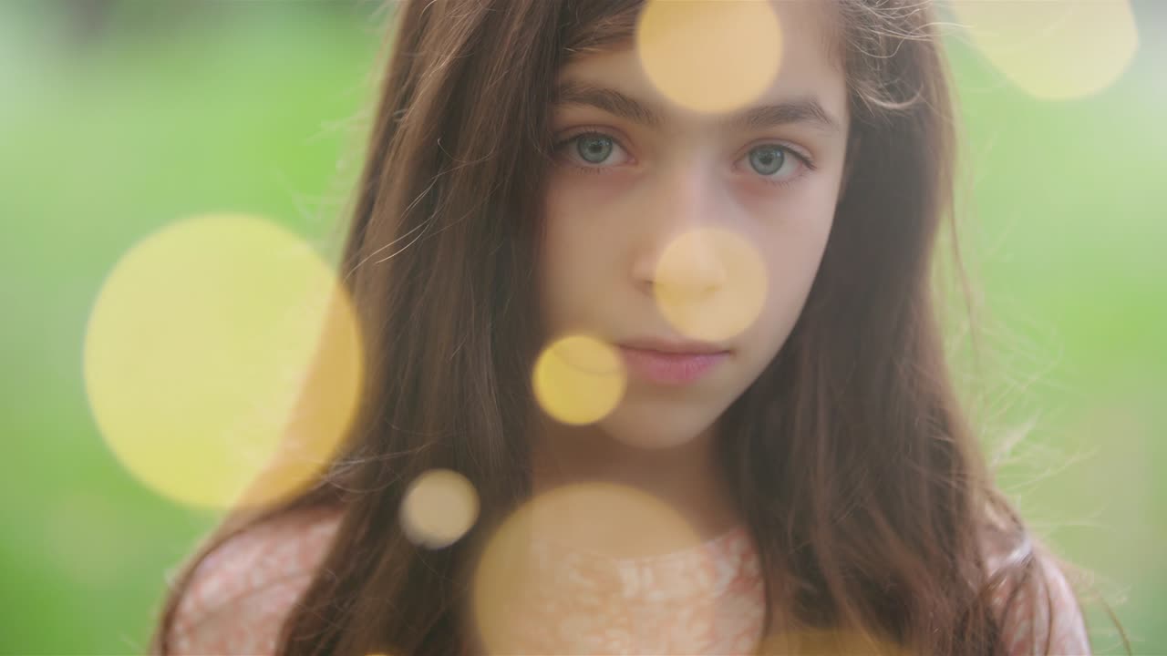 젊은 소녀는 bokeh 오른쪽으로 진지하게 쳐다보고