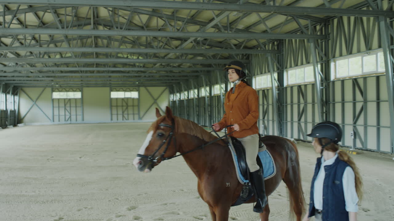 Woman Riding Horse under Control of Instructor