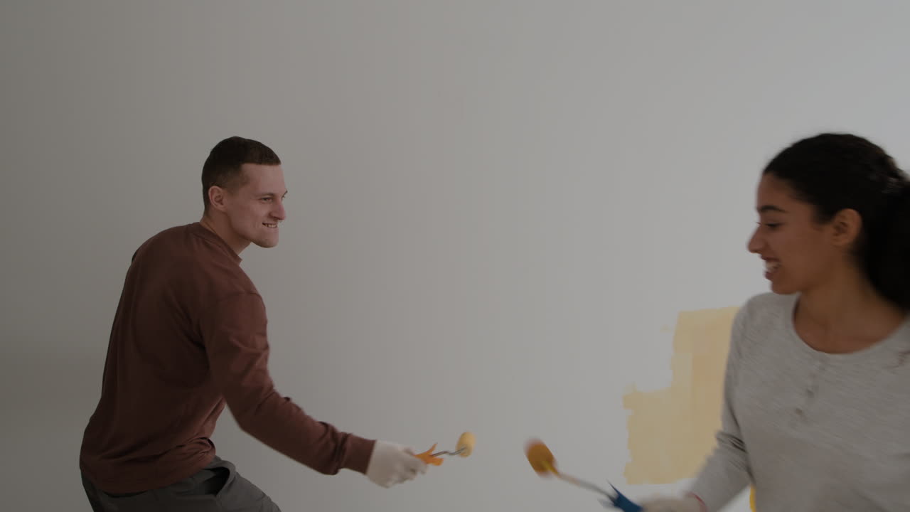Happy Couple Painting Their New Home Together