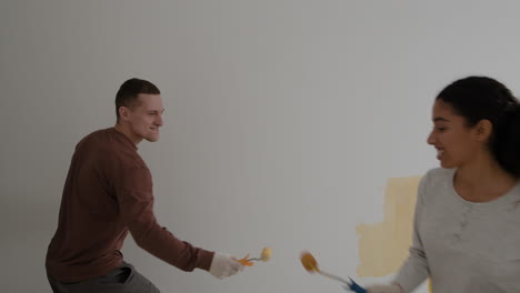 happy couple painting their new home together