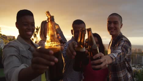 grupo de amigos bebiendo una cerveza en un tejado