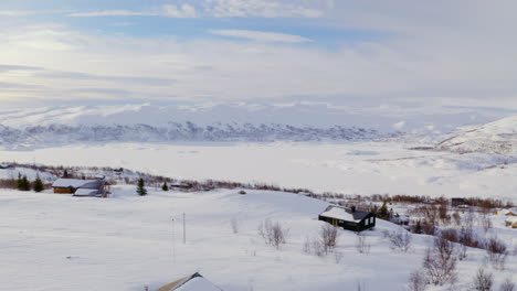 Mountainside-Cabins-And-Snow-Covered-Mountains-In-Huagastol-Norway---Aerial-shot