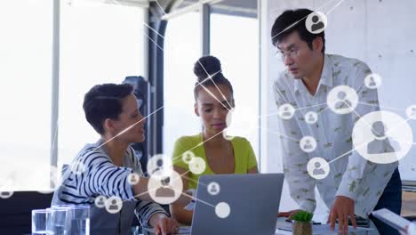 Animation-of-network-of-profile-icons-against-team-of-diverse-colleagues-discussing-at-office