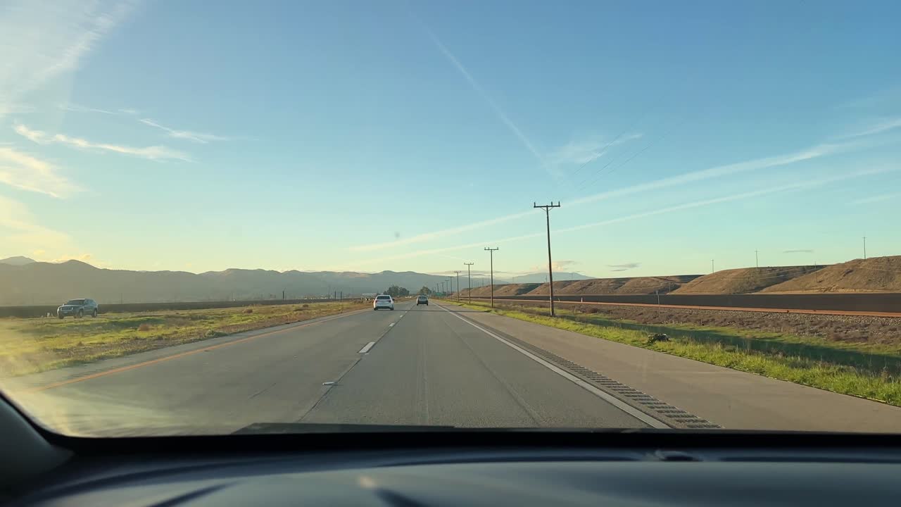 POV shot from a moving vehicle on Highway 101 through farmland in Central California. 4K