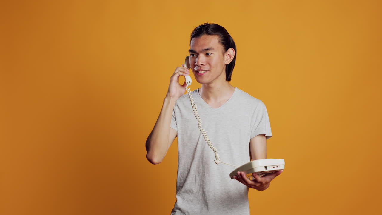 Young person answering landline phone call on camera