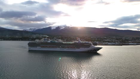 desde el aire: enorme crucero navegando a lo largo de la pintoresca costa de islandia durante la puesta de sol