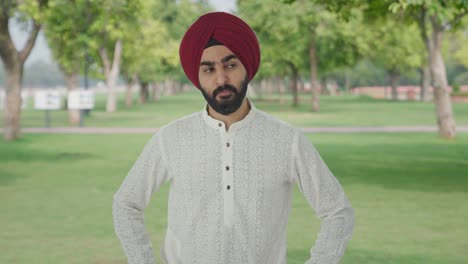 angry sikh indian man looking to the camera in park