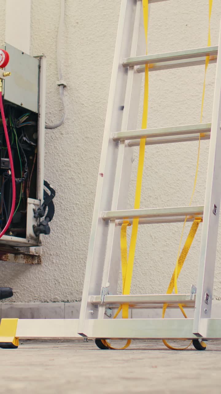 Vertical video Mechanic climbing folding ladder
