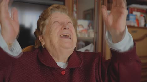 stationary close-up on ecstatic aged white woman lifting hands