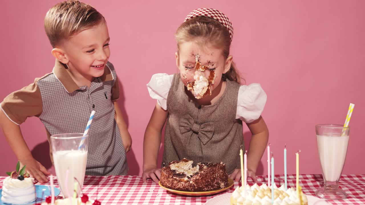 los niños celebran su cumpleaños con un pastel desordenado.