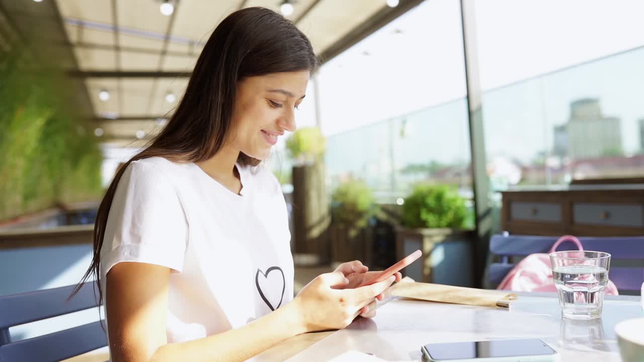 mujer joven usando un teléfono inteligente en un café