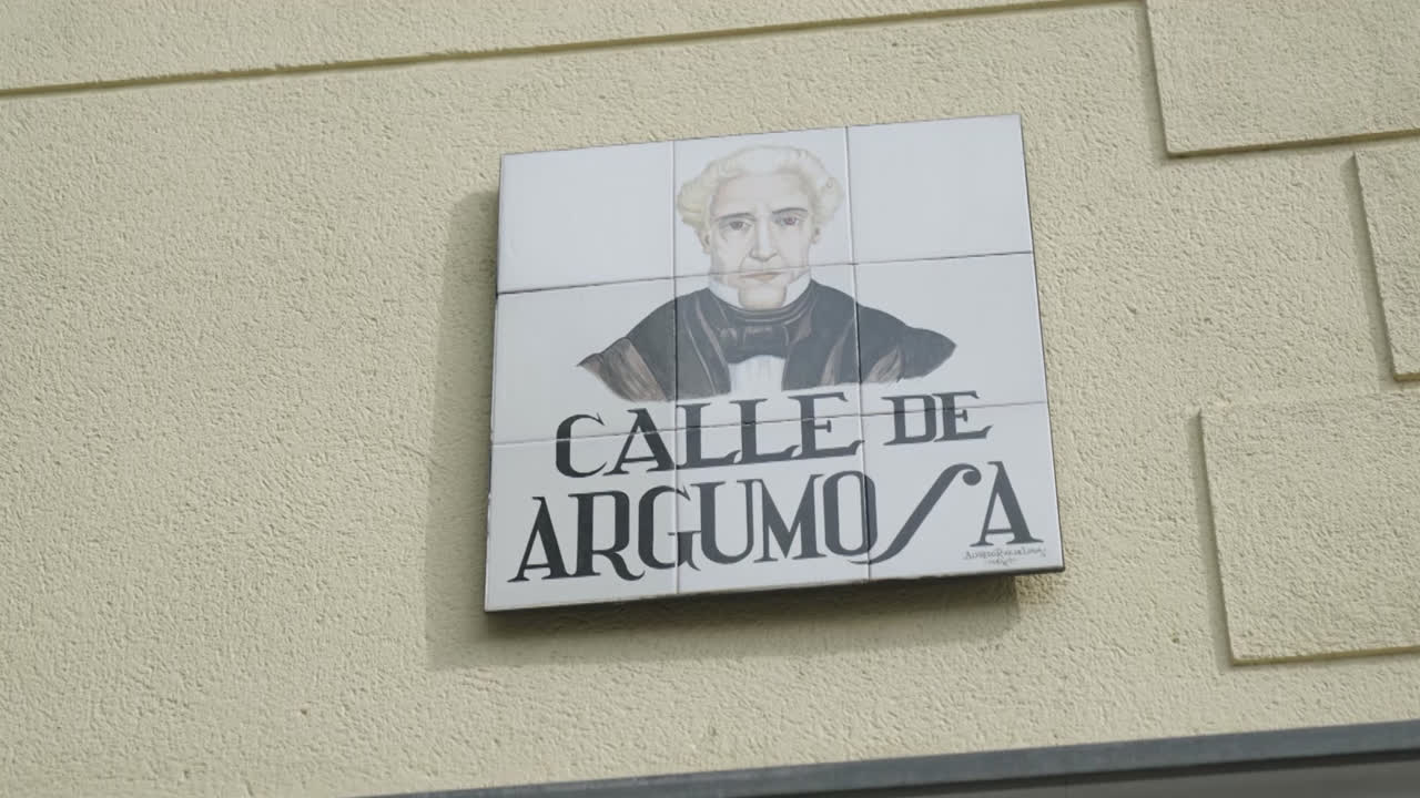 Beautiful close-up zoom in shot of a "Calle de Argumosa" sign in downtown Madrid during the day.