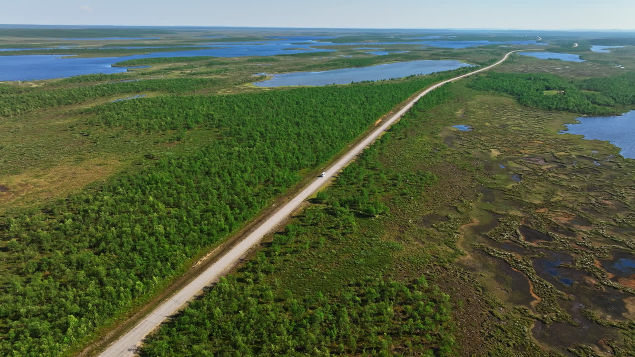 drone rastreando una furgoneta conduciendo en la naturaleza ártica, día de verano en kaldoaivi, finlandia