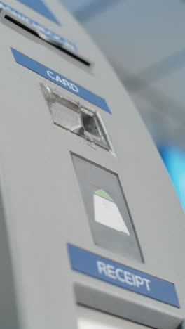 person inserting card into atm machine