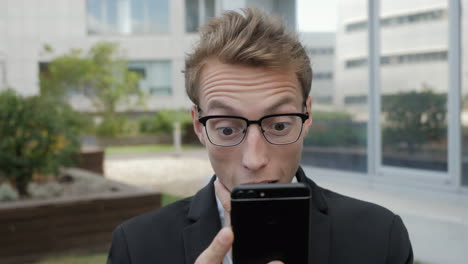 man receiving news on phone, looking surprised and shocked