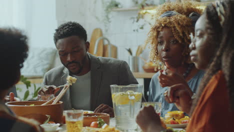 parents and kids talking and smiling during family dinner at home