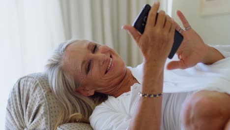 Disabled-woman-using-mobile-phone-in-living-room-4k