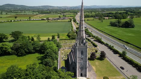 The-Marble-Church,-Bodelwyddan,-Wales---Neo-Gothic,-aerial-drone-anti-clockwise-pan,-move-in-and-focus-on-steeple---June-23