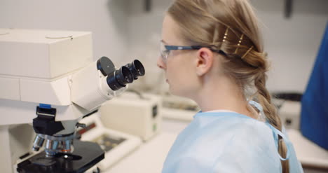 científico examinando bacterias bajo el microscopio en el laboratorio 2