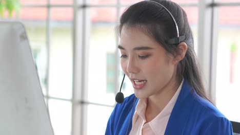 businesswoman wearing headset working actively in office