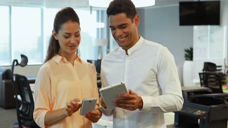 colegas de trabajo discutiendo a través de dispositivos electrónicos