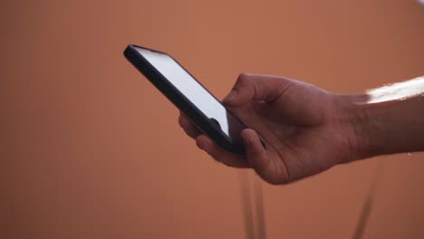 close up of a man's hand texting on the mobile phone