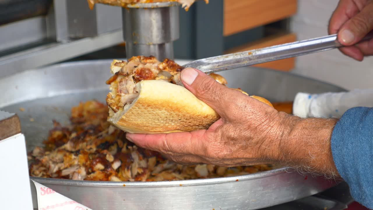 Un uomo che prepara un panino döner kebab