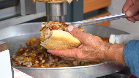 a man making a doner kebab sandwich