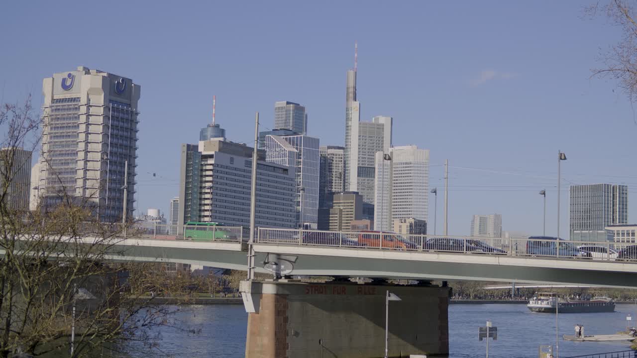 Modern bridge over river with skyscrapers of Frankfurt in the background